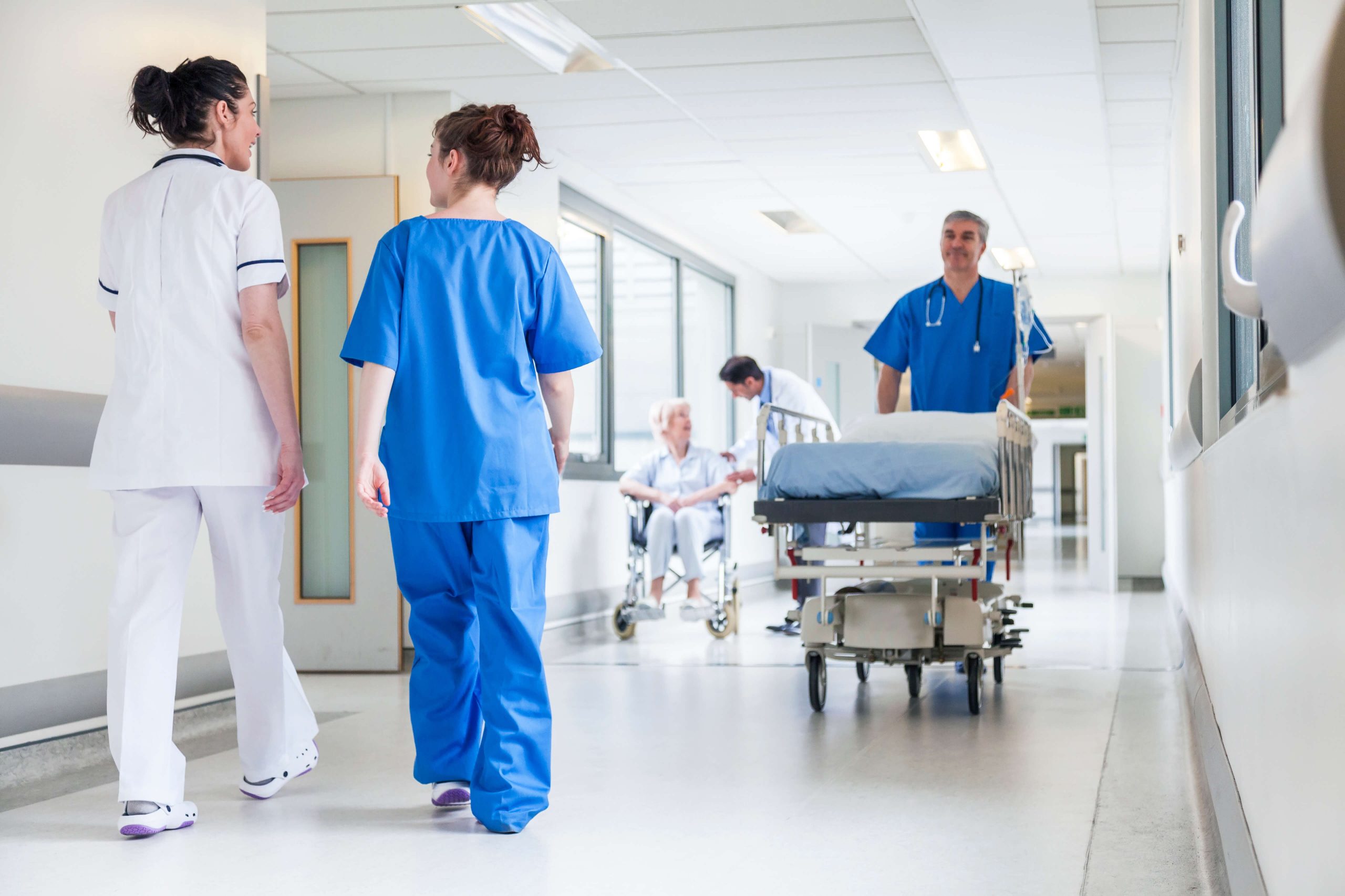 nurses walking down a hospital hallway talking to each other