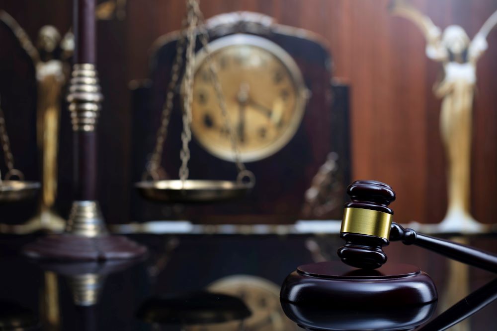 A gavel sitting next to an old clock to represent the need to file a claim within the statute of limitations.