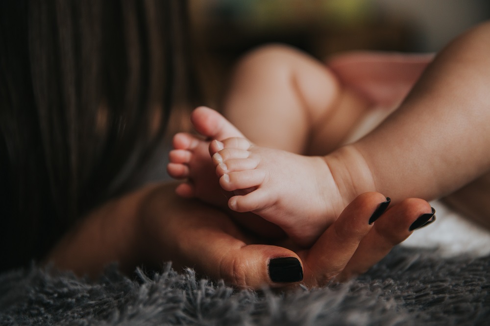 Mom holding baby's feet, how to recognize failure to diagnose during pregnancy graphic